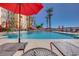 Community pool with seating areas, palm trees, and clear blue water for relaxation and recreation at 2455 W Serene Ave # 603, Las Vegas, NV 89123