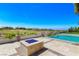 Backyard oasis featuring a stone fire pit, built-in grill, and panoramic views of the golf course and mountains at 2600 Cervino Cir, Henderson, NV 89052