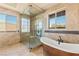 Spa-like bathroom with walk-in shower, soaking tub, and designer tile work at 2600 Cervino Cir, Henderson, NV 89052
