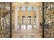 Ornate iron gates lead into the grand foyer featuring soaring ceilings, columns, and golf course views at 2600 Cervino Cir, Henderson, NV 89052
