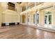 Large living room area featuring columns, high ceilings, wood floors, and views to exterior landscaping at 2600 Cervino Cir, Henderson, NV 89052
