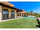 Beautiful backyard with a sparkling pool, manicured lawn, and covered patio, perfect for outdoor living at 2600 Cervino Cir, Henderson, NV 89052