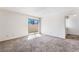 Bright bedroom with neutral carpet, white walls, and sliding glass doors leading to a balcony at 2667 Aracatuba Ave, Las Vegas, NV 89121