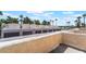 Eye-level outdoor view showcases townhome garages and palm trees under a blue, partly cloudy sky at 2667 Aracatuba Ave, Las Vegas, NV 89121