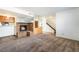 Inviting living room with a cozy brick fireplace, plush carpeting, and an open staircase at 2667 Aracatuba Ave, Las Vegas, NV 89121