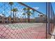 Chain-link fence view of a tennis court with townhomes and palm trees in the background at 2667 Aracatuba Ave, Las Vegas, NV 89121