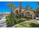 Clubhouse exterior featuring desert landscaping with manicured shrubs and tall palm trees against a clear blue sky at 2925 Wigwam Pkwy # 923, Henderson, NV 89074