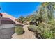 This beautifully landscaped backyard features palm trees, gravel, and mature shrubbery at 3008 Hot Cider Ave, North Las Vegas, NV 89031
