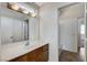 Bright bathroom featuring wood cabinets, a mirror with lighting, and tiled floors at 3008 Hot Cider Ave, North Las Vegas, NV 89031