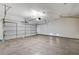 View of an empty two-car garage with a concrete floor, lights, and a white door at 3008 Hot Cider Ave, North Las Vegas, NV 89031