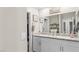 Bathroom with double sinks, white cabinets, granite countertop, and decorative wall decor at 333 Canary Song Dr, Henderson, NV 89011