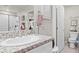 Bathroom featuring granite countertop, framed mirror, and a shower-tub with a glass door at 333 Canary Song Dr, Henderson, NV 89011