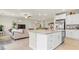 Open floor plan with island connecting kitchen and living room with stainless steel appliances and a large sofa at 333 Canary Song Dr, Henderson, NV 89011