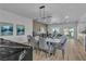 Bright dining area features modern chandelier and view to living area with wood accent wall at 4434 Verdiccio Ave, Las Vegas, NV 89141