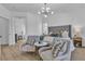 Bright main bedroom showcasing a plush bed, hardwood floors, and a modern light fixture above a sitting area at 4434 Verdiccio Ave, Las Vegas, NV 89141