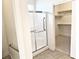 Bathroom features glass shower with silver trim and safety bars, next to a walk-in closet with shelving at 4695 E Lucera Ct, Pahrump, NV 89061