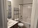 Bathroom with tub-shower combo, white fixtures and vanity with dark wood cabinets at 4695 E Lucera Ct, Pahrump, NV 89061