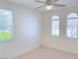 Bedroom with large windows offering natural light, neutral carpet, and ceiling fan at 4695 E Lucera Ct, Pahrump, NV 89061