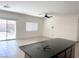 Kitchen area featuring an island with a dark countertop, backyard access, and ceiling fan at 4695 E Lucera Ct, Pahrump, NV 89061