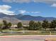 Picturesque pond view with a fountain, framed by mature trees and the snow capped mountains in the background at 4695 E Lucera Ct, Pahrump, NV 89061