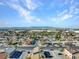Wide aerial view showcasing neighborhood homes and city landscape against a mountain range at 4708 Thunderbolt Ave, Las Vegas, NV 89115