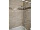 Bathtub with shower featuring decorative tile border and handheld shower head at 4708 Thunderbolt Ave, Las Vegas, NV 89115