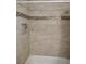 Bathtub with shower, neutral tile and a decorative glass tile border at 4708 Thunderbolt Ave, Las Vegas, NV 89115