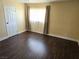 A spacious bedroom with dark wood floors, large window, and a white door at 4708 Thunderbolt Ave, Las Vegas, NV 89115