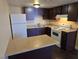 A compact kitchen with an island, laminate countertops, and dark wood cabinets at 4708 Thunderbolt Ave, Las Vegas, NV 89115