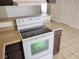 Kitchen with white stove, neutral countertops, and dark cabinets at 4708 Thunderbolt Ave, Las Vegas, NV 89115