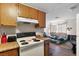 The combined kitchen and living room has matching wooden cabinets and white appliances at 4708 Thunderbolt Ave, Las Vegas, NV 89115