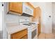 Cozy kitchen featuring oak cabinets, white appliances, and neutral countertops at 4847 Double Down Dr # 101, Las Vegas, NV 89122