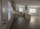 Open floor plan showcasing updated kitchen, stainless appliances, and wood-look flooring at 4905 Danbrook Ct, Las Vegas, NV 89110