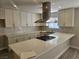 Modern kitchen with white cabinets, quartz countertop island, and stainless steel hood at 4905 Danbrook Ct, Las Vegas, NV 89110