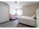 Bright bedroom features two beds and neutral color palette, and gray flooring at 4923 Strauss Dr, Las Vegas, NV 89146
