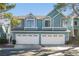 Charming two-story townhouse with two-car garage, blue siding and manicured landscaping at 4923 Strauss Dr, Las Vegas, NV 89146