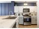Bright kitchen with marbled countertops, stainless appliances, and custom backsplash at 4923 Strauss Dr, Las Vegas, NV 89146