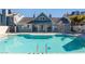 Community pool with clear, blue water, modern blue building with shade awning at 4923 Strauss Dr, Las Vegas, NV 89146