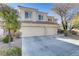 Two-story home featuring a spacious driveway leading to a two-car garage with desert landscaping around the house at 501 Tuscany View St, Las Vegas, NV 89145