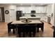 Modern kitchen with sleek white cabinets, stainless steel appliances, and central island with bar stool seating at 5230 Lissome Lily Ct, Las Vegas, NV 89139