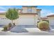 Charming two-story townhome showcasing a front yard with a tree and a convenient two-car garage at 5421 Painted Mirage Rd, Las Vegas, NV 89149