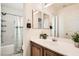 Well-lit bathroom with a shower-tub combo, double mirrors, vanity with cabinet and decorative plants at 5958 W Agate Ave, Las Vegas, NV 89139