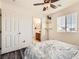 Bright bedroom featuring a ceiling fan, wood floors, a large window and an ensuite bathroom at 5958 W Agate Ave, Las Vegas, NV 89139