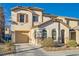 Two-story home with tan exterior, shuttered windows and a one car garage on a sunny day at 5958 W Agate Ave, Las Vegas, NV 89139