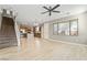 Open-concept living room with wood floors, staircase, view of kitchen, and a ceiling fan at 7222 Regent Pond St, Las Vegas, NV 89166