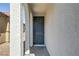 Inviting covered front entrance with textured walls and stylish gray front door at 7256 Saxby Ave, Las Vegas, NV 89113