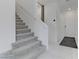 Carpeted staircase with white walls and a view of the entry hall at 7256 Saxby Ave, Las Vegas, NV 89113