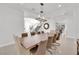 Bright dining room with a large wood table, decorative chandelier, and staircase in an open-concept home design at 807 Canyon Greens Dr, Las Vegas, NV 89144