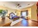 This main bedroom features hardwood floors, a ceiling fan, a seating area and a king-size bed at 8209 Chapelle Ct, Las Vegas, NV 89131