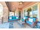 Covered patio featuring comfortable seating, stone accents, and a view of the backyard oasis at 8209 Chapelle Ct, Las Vegas, NV 89131